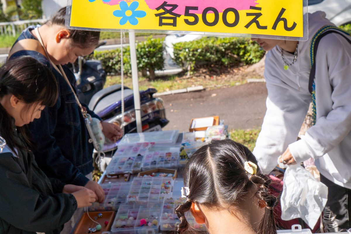 値札の看板を出した出店で商品を選ぶお客さん